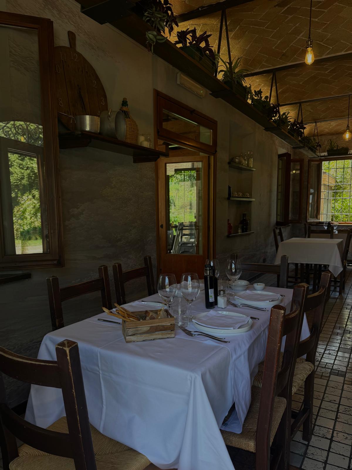 Tavolo apparecchiato in sala rustica dell'Agriturismo San Polo a Castelvetro di Modena, con candele e tovaglia di lino